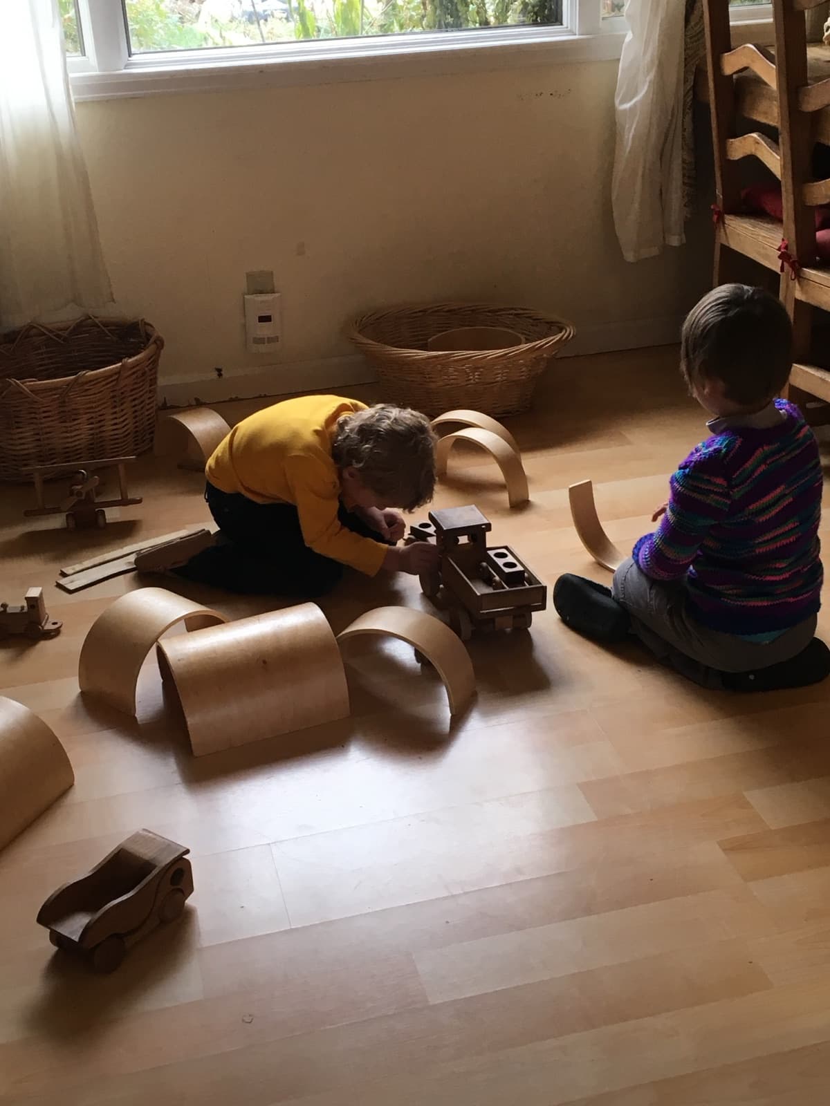 Morning block play with wooden arches, baskets, and a hand-carved truck