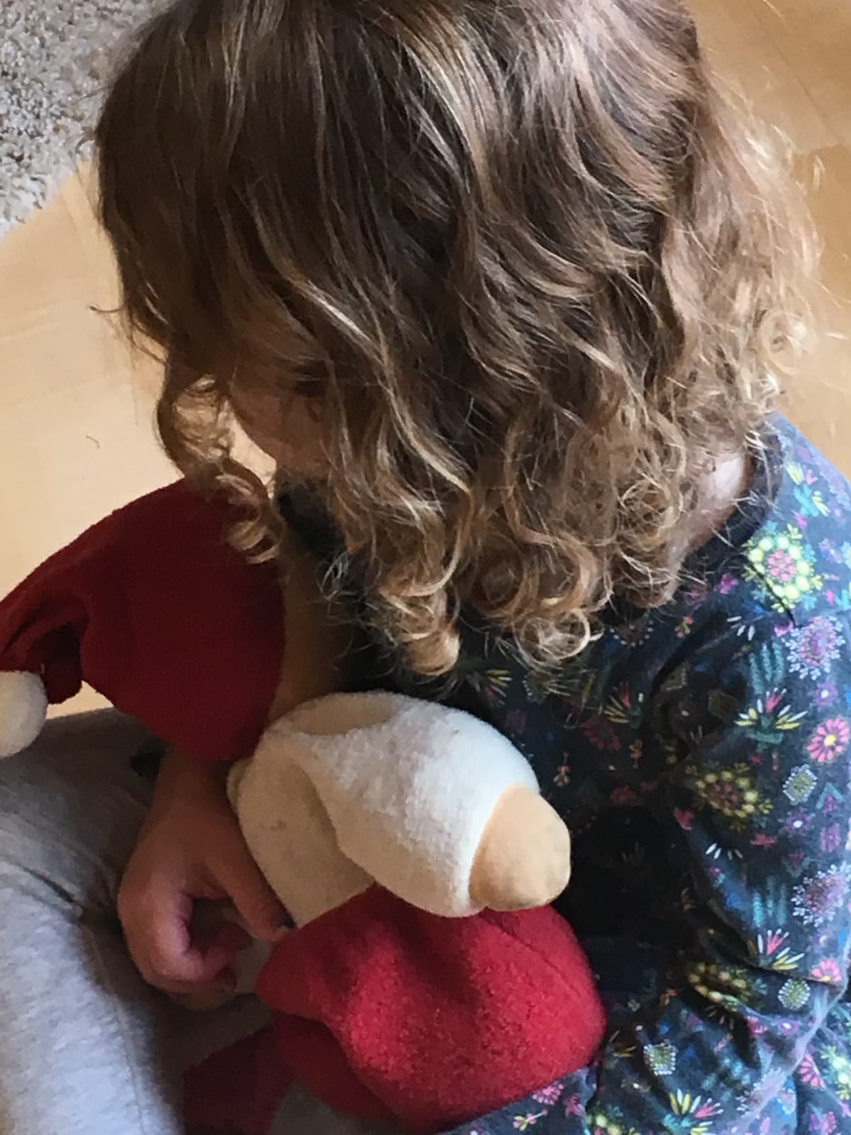A child hugging a beloved handmade doll close