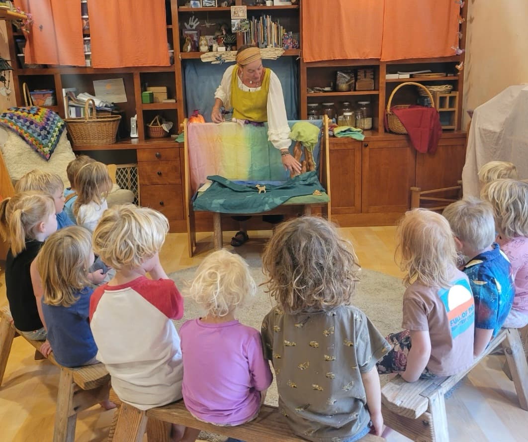 Story time in the classroom, children gathered on wooden benches