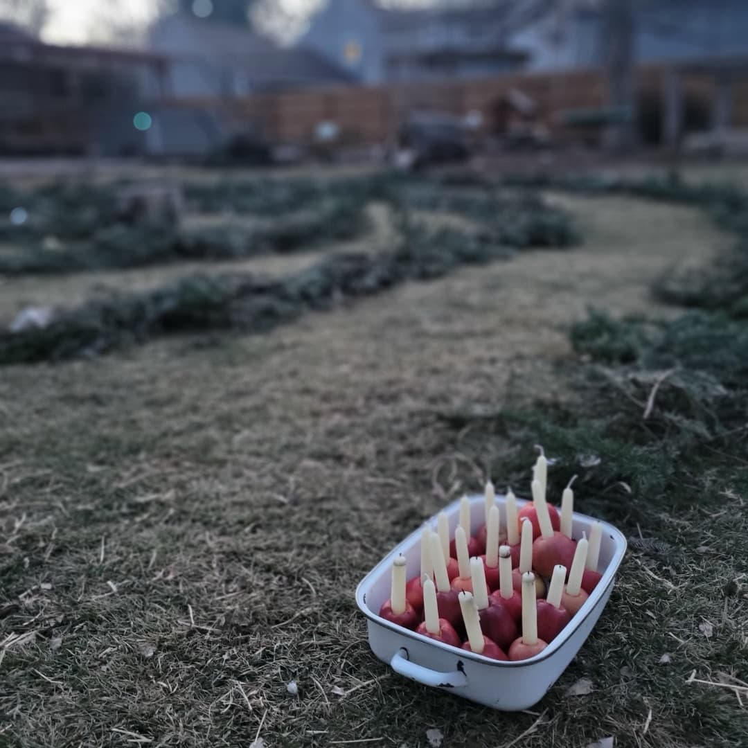 A tray of red apples, each holding a small candle, waiting beside the spiral